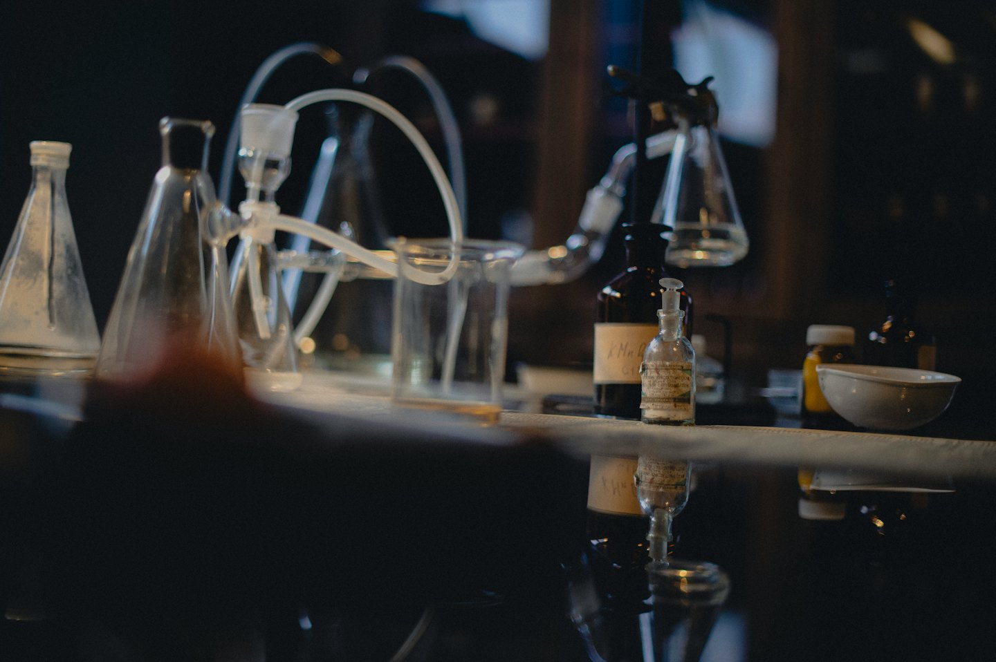 Laboratory glassware arranged on a reflective surface.