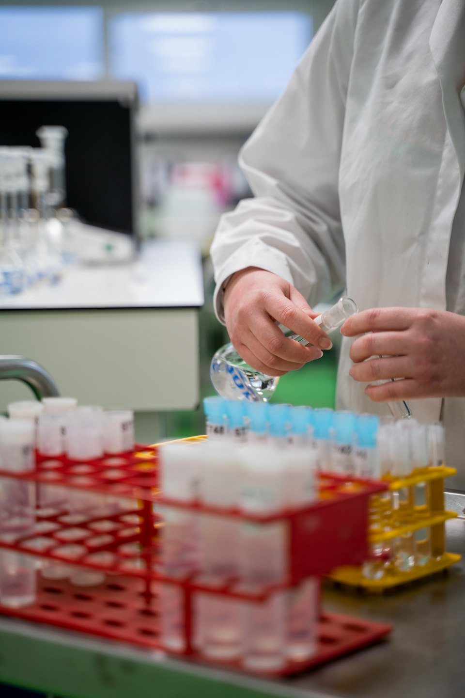 Scientist carefully pours liquid into a test tube.